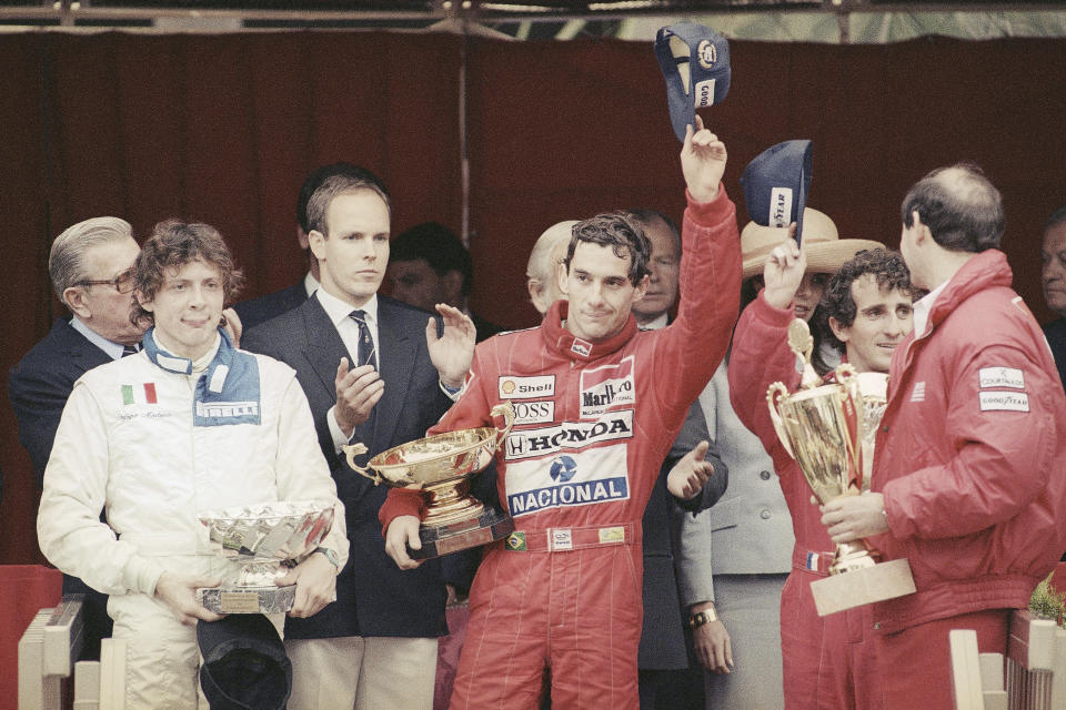 FILE - Prince Albert of Monaco, left, applauds Brazil's Ayrton Senna, center, winner of the Monaco formula One grand prix ahead of Prost, right, on the podium in Monaco Sunday, May 7, 1989. The 30th anniversary of Ayrton Senna’s death is commemorated with a memorial on the Imola track where he crashed during the 1994 San Marino Grand Prix. (AP Photo/Gilbert Tourte, File)
