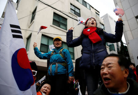 Supporters of South Korea's ousted leader Park Geun-hye wave the national flags of South Korea and the U.S. as they wait for her arrival outside her private home in Seoul, South Korea, March 12, 2017. REUTERS/Kim Kyung-Hoon