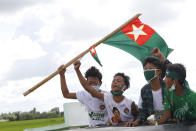 Supporters of the military-backed Union Solidarity and Development Party (USDP) wave the party flags and cheer from trucks during an election campaign for next month's general election, Thursday, Oct. 1, 2020, in Naypyitaw, Myanmar. (AP Photo/Aung Shine Oo)