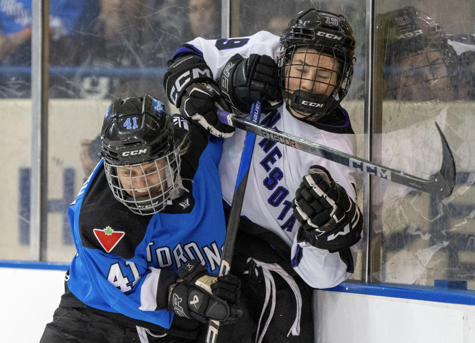 Toronto's Brittany Howard (41) drives Minnesota's Maggie Flaherty (19) into the boards during the second period of a PWHL hockey game in Toronto on Wednesday May 1, 2024. (Frank Gunn/The Canadian Press via AP)