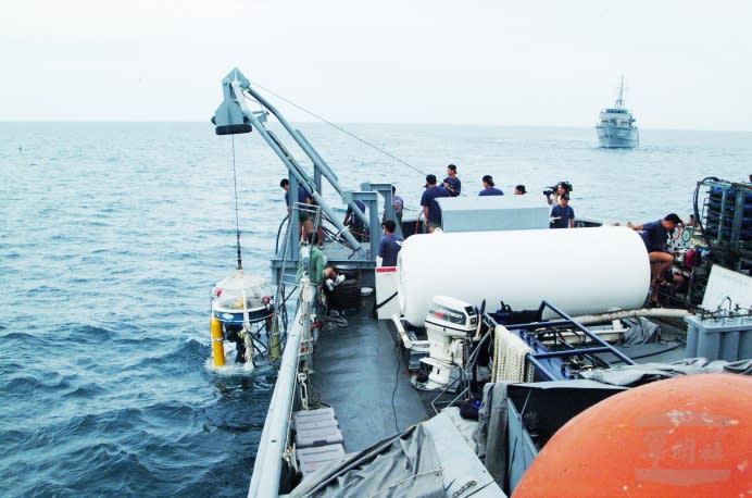 2002年6月，「大湖軍艦」吊掛潛水鐘，由兩名海軍救難大隊潛水人員下潛至水深220餘呎的海底，並由後方的獵雷艦導引，進行飛航資料記錄器的搜尋。 （軍聞社資料照片）