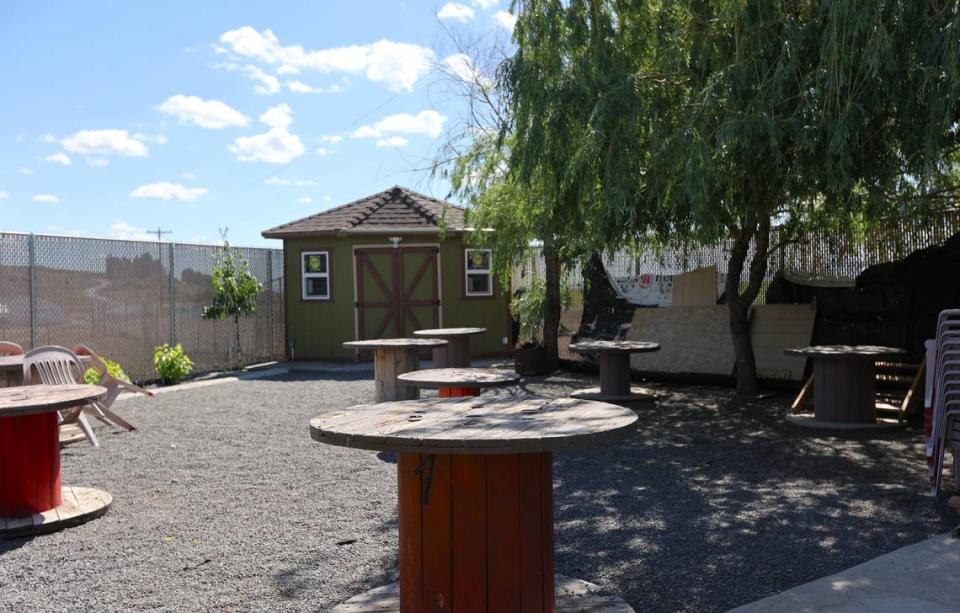 The backyard at Ringold in Mesa, WA, features wood tables and plastic chairs where farmworkers can enjoy a meal cooked by housing manager Jose Avila and his wife, who live on-site.