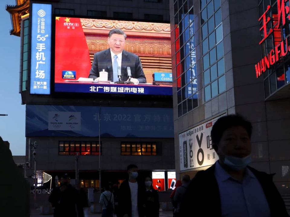 A giant screen shows news footage of Chinese President Xi Jinping attending a video summit on climate change earlier this year. Will China be able to meet Xi's targets? (Florence Lo/Reuters - image credit)