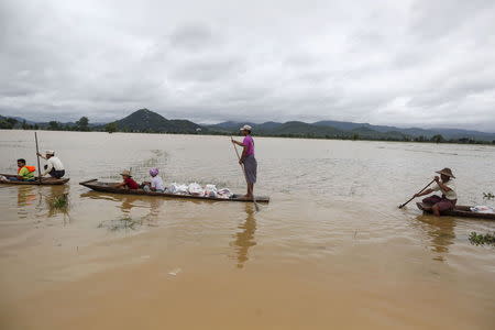 Residents transport aid on boats for their flooded village at Kawlin township, Sagaing division, Myanmar July 23, 2015. REUTERS/Soe Zeya Tun/Files