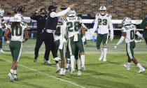 Charlotte coach Will Healy celebrates a turnover with his players during the first half against Duke in an NCAA college football game Saturday, Oct. 31, 2020, in Durham, N.C. (Jaylynn Nash/Pool Photo via AP)