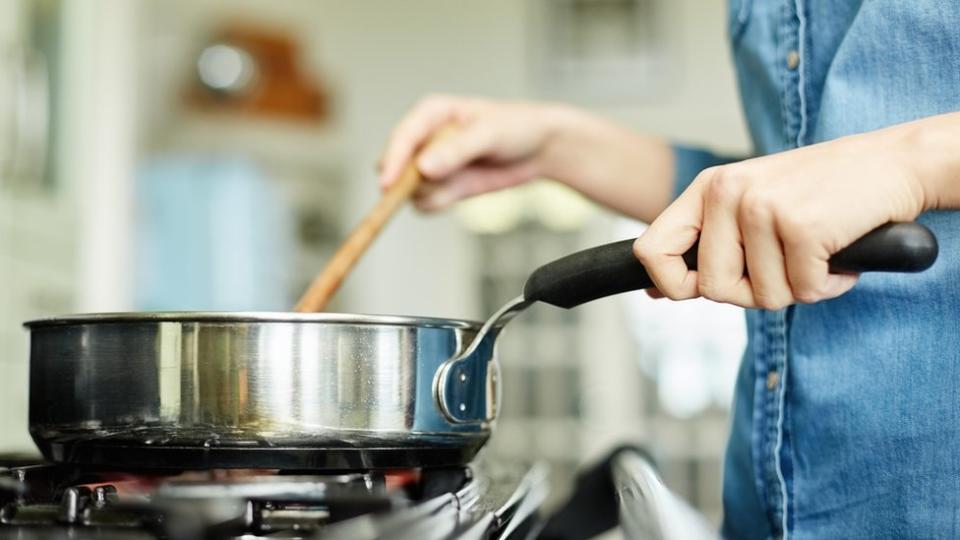 Person cooking on a gas hob