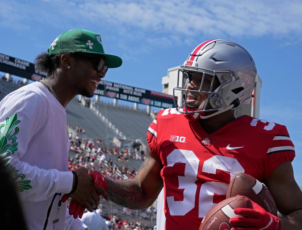 April 15, 2023; Columbus, Ohio, USA;  Running back TreVeyon Henderson (32) is greeted by former wide receiver Garrett Wilson before the Ohio State spring football game Saturday at Ohio Stadium.Mandatory Credit: Barbara J. Perenic/Columbus Dispatch