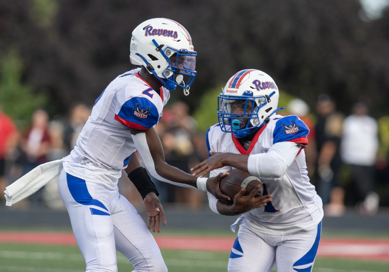 Ravenna quarterback CJ Ross hands off to Amare Marshall.