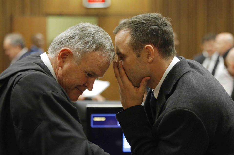 Oscar Pistorius, talks with his attorney, Barry Roux, left, inside court on the second day of his trial at the high court in Pretoria, South Africa, Tuesday, March 4, 2014. Pistorius is charged with murder for the shooting death of his girlfriend, Reeva Steenkamp, on Valentines Day in 2013. (AP Photo/Kim Ludbrook,Pool)