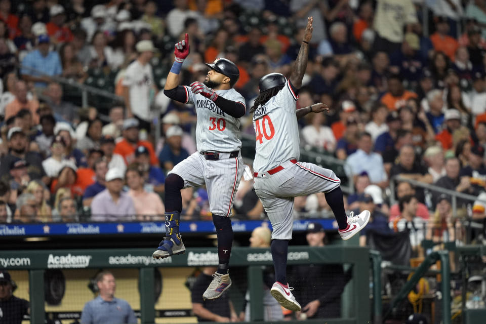 Minnesota Twins' Carlos Santana (30) celebrates with third base coach Tommy Watkins (40) after hitting a home run against the Houston Astros during the eighth inning of a baseball game Friday, May 31, 2024, in Houston. (AP Photo/David J. Phillip)