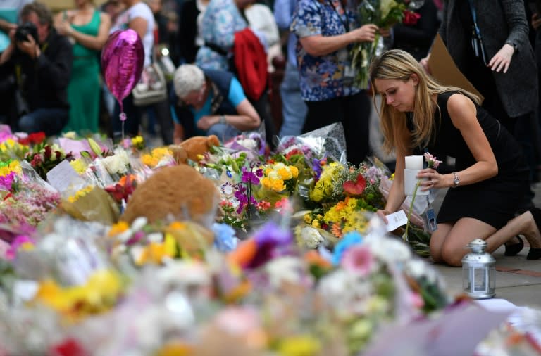 People lay flowers in tribute to the victims of the May 22 bomb attack in Manchester in northern England