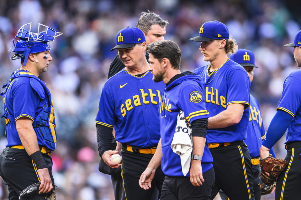 Seattle Mariners manager Scott Servais, second from left, pulls starting pitcher Bryce Miller, right, after an injury delay during the fourth inning of the team's baseball game against the Tampa Bay Rays, Friday, June 30, 2023, in Seattle. (AP Photo/Caean Couto)