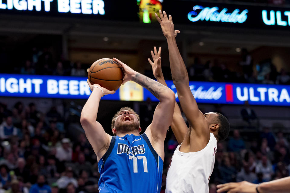 Dallas Mavericks guard Luka Doncic (77) draws a foul on Cleveland Cavaliers forward Evan Mobley (4) while attempting a shot in the first half of an NBA basketball game in Dallas, Wednesday, Dec. 14, 2022. (AP Photo/Emil Lippe)