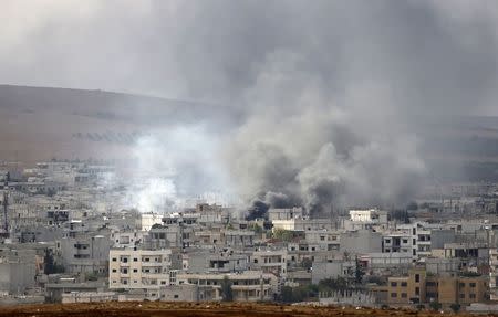 Smoke rises from the Syrian town of Kobani, seen from near the Mursitpinar border crossing on the Turkish-Syrian border in the southeastern town of Suruc in Sanliurfa province October 12, 2014. REUTERS/Umit Bektas