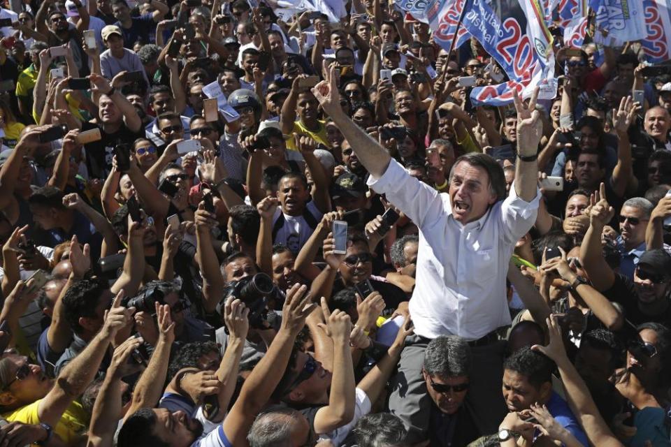 Jair Bolsonaro greets supporters as he gets a shoulder ride in Brasilia’s Ceilandia neighbourhood on the previous day.