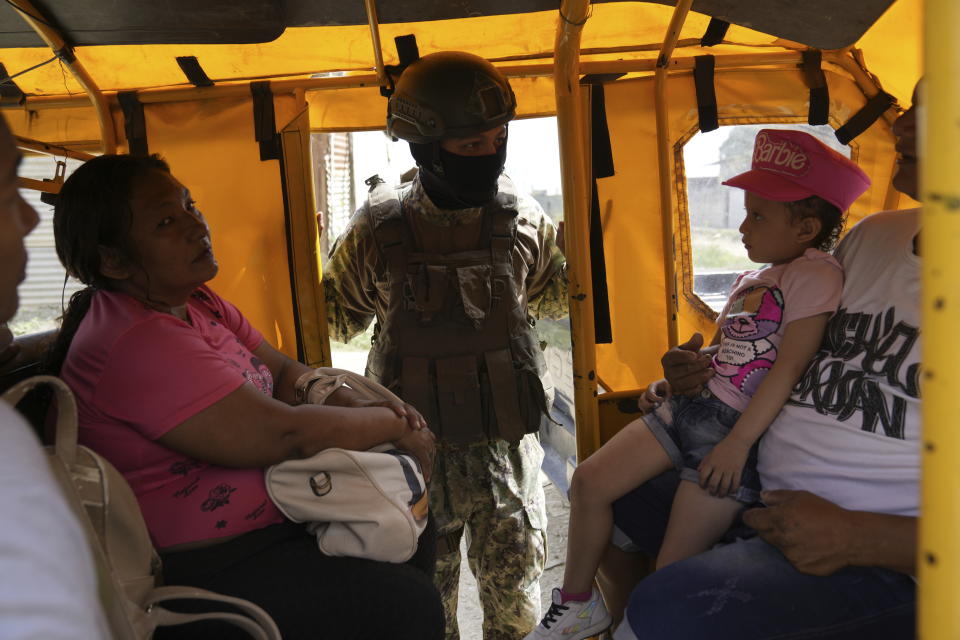 A soldier peers into public transportation at a security check placed by the army in Duran, across a bridge from Guayaquil, Ecuador, Monday, Aug. 14, 2023. Ecuador's president declared a state of emergency in some areas after a presidential candidate was killed at a rally ahead of snap elections, set for Aug. 20, after President Guillermo Lasso dissolved the National Assembly to avoid being impeached. (AP Photo/Martin Mejia)