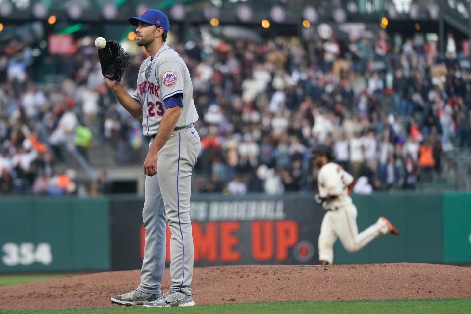 New York Mets pitcher David Peterson, left, reacts as San Francisco Giants' Brandon Crawford, rear, rounds the bases after hitting a two-run home run during the second inning of a baseball game in San Francisco, Monday, May 23, 2022.