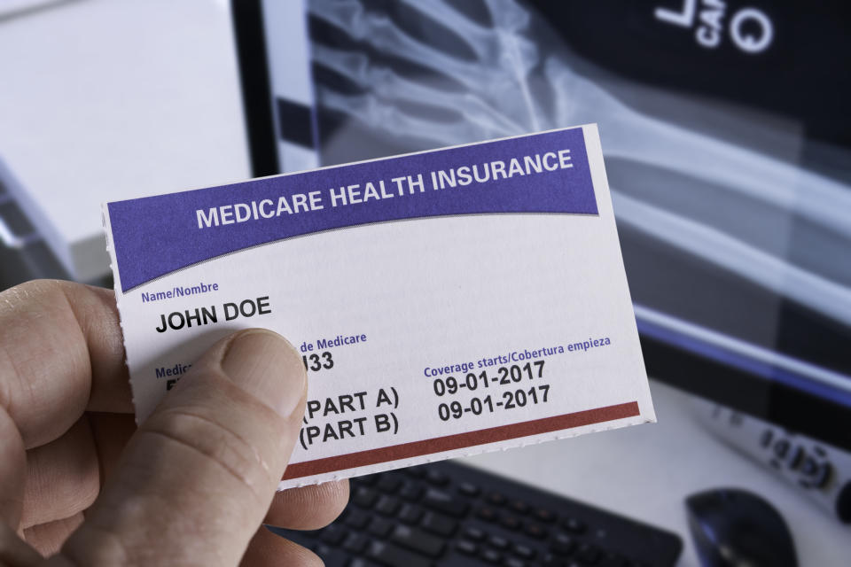 Medicare Health Insurance Card in medical office with Xray and hand