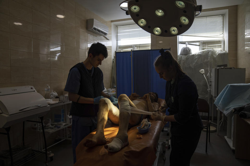 Medical workers treat Volodymyr Nikiforov, 40, injured by shelling near Barvenkove at a hospital in Kramatorsk, eastern Ukraine, Tuesday, April 26, 2022. (AP Photo/Evgeniy Maloletka)