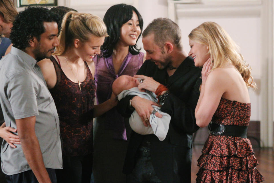 A group of people smiling at a baby in church; still from 'Lost'