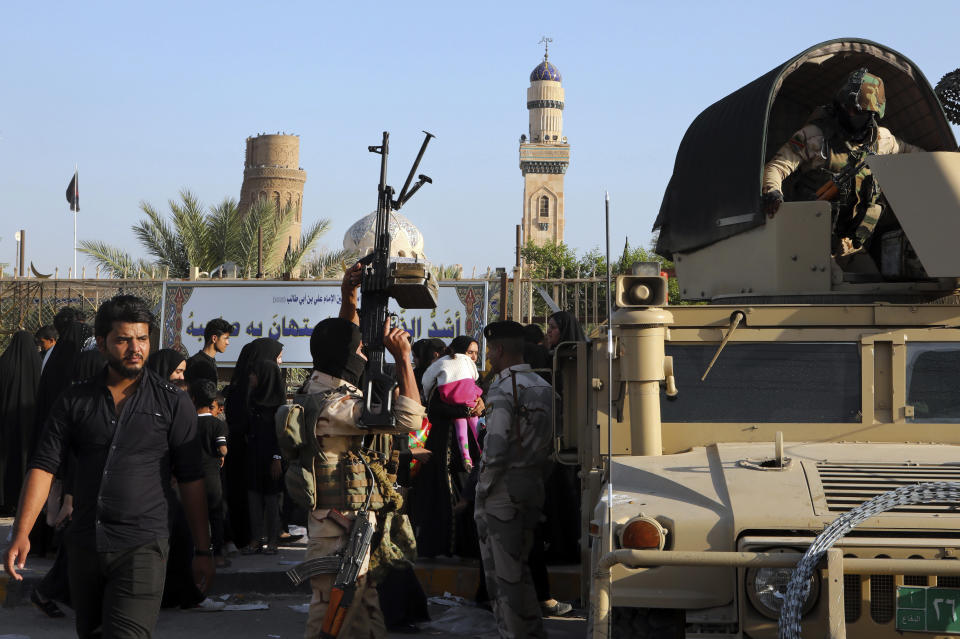 In this Oct. 30, 2018, photo Iraqi Security forces guard while the Shiite faithful pilgrims on their way to perform their rituals in Basra, Iraq. Synagogues, mosques, churches and other houses of worship are routinely at risk of attack in many parts of the world. And so worshippers themselves often feel the need for visible, tangible protection even as they seek the divine. (AP Photo/Nabil al-Jurani)
