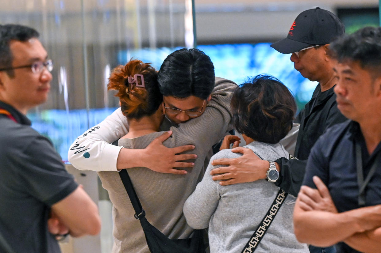 Passengers of Singapore Airlines flight SQ321 from London to Singapore, which made an emergency landing in Bangkok, greet family members upon arrival at Changi Airport in Singapore on May 22, 2024. A 73-year-old British man died and more than 70 people were injured May 21, 2024 in what passengers described as a terrifying scene aboard a Singapore Airlines flight that hit severe turbulence, triggering an emergency landing in Bangkok. (Photo by Roslan RAHMAN / AFP) (Photo by ROSLAN RAHMAN/AFP via Getty Images)