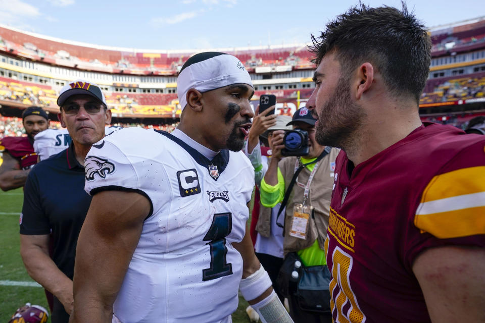 Washington Commanders head coach Ron Rivera, left, watching Philadelphia Eagles quarterback Jalen Hurts (1) greeting Washington Commanders quarterback Sam Howell (14) at the end of an NFL football game, Sunday, Oct. 29, 2023, in Landover, Md. Eagles won 38-31. (AP Photo/Alex Brandon)