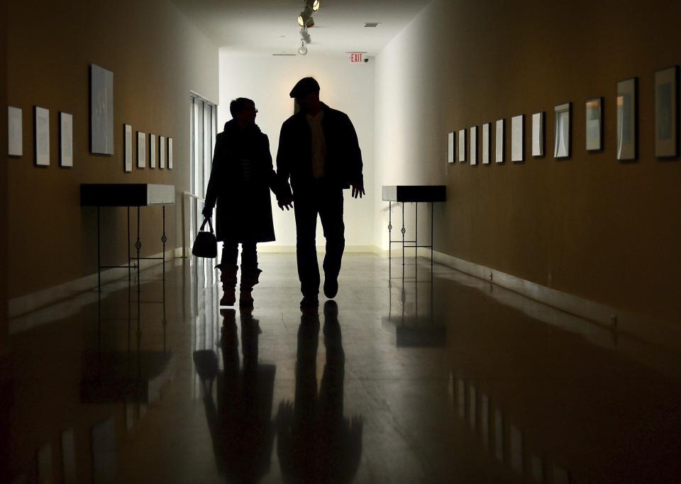 FILE - A couple walks down the Bacon Gallery at the Erie Art Museum, in Erie, Pa., Jan. 7, 2014. A section of the new $1.7 trillion spending bill from Congress has been billed as a dramatic step toward shoring up retirement accounts of millions of workers. (Jarid A. Barringer/Erie Times-News via AP, File)