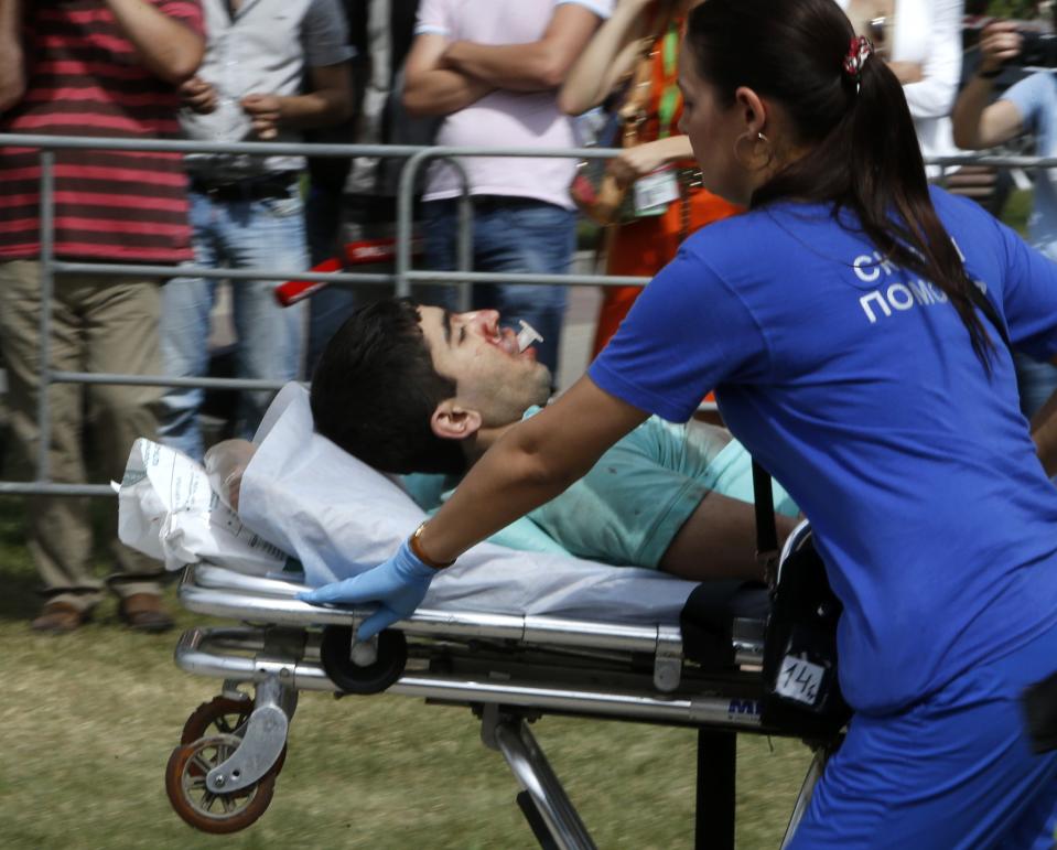 Members of the emergency services carry an injured passenger outside a metro station following an accident on the subway in Moscow July 15, 2014. Five people were killed and nearly 100 were injured when an Moscow underground train went off the rails between two stations during the morning rush hour on Tuesday, the Health Ministry said. (REUTERS/Sergei Karpukhin)