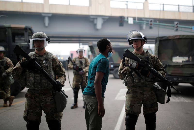 A man confronts a National Guard member as they guard the area in the aftermath of a protest in Minneapolis