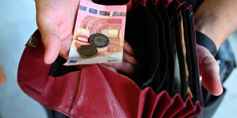 Ein Kellner eines Restaurants hält einen Geldbeutel in der Hand. (Bild: Felix Hörhager/dpa)