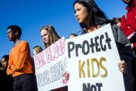 <p>Grand Blanc High School juniors Anneliese Hull, center left, and Tasha Kue stand tall while holding protest signs in a moment of silence, Friday, April 20, 2018, in Grand Blanc, Mich., as they took part in a national school walkout event to protest gun violence. (Photo: Jake May/The Flint Journal-MLive.com via AP) </p>