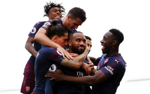 Alexandre Lacazette celebrates with teammates after scoring his team's second goal during the Premier League match between Fulham FC and Arsenal FC - Credit: Catherine Ivill/Getty Images