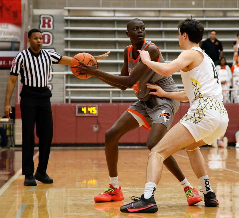 OU commit, Haltom forward Kuol Atak (22) looks to pass around Highland Park guard Will Saunders (4) in the first period of a UIL Conference 6A Division 1 boys bi-district basketball playoff game at Lewisville High School in Lewisville, Texas, Tuesday, Feb. 20, 2024.