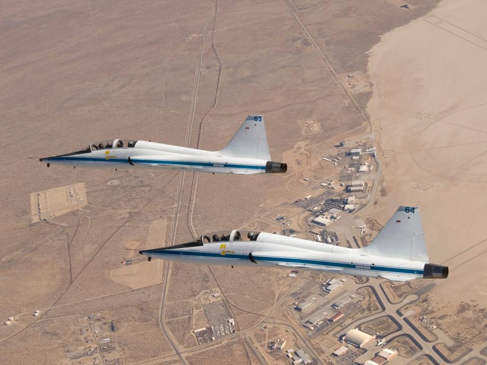 NASA Dryden's two T-38A mission support aircraft fly in tight formation while conducting a pitot-static airspeed calibration check near Edwards Air Force Base.