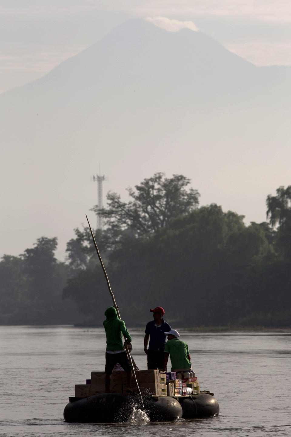 Rafts carry merchandise across the Suchiate river between Tecun Uman, Guatemala, and Ciudad Hidalgo, Mexico, Friday, June 21, 2019. Mexico's foreign minister says that the country has completed its deployment of some 6,000 National Guard members to help control the flow of Central American migrants headed toward the U.S. (AP Photo/Oliver de Ros)