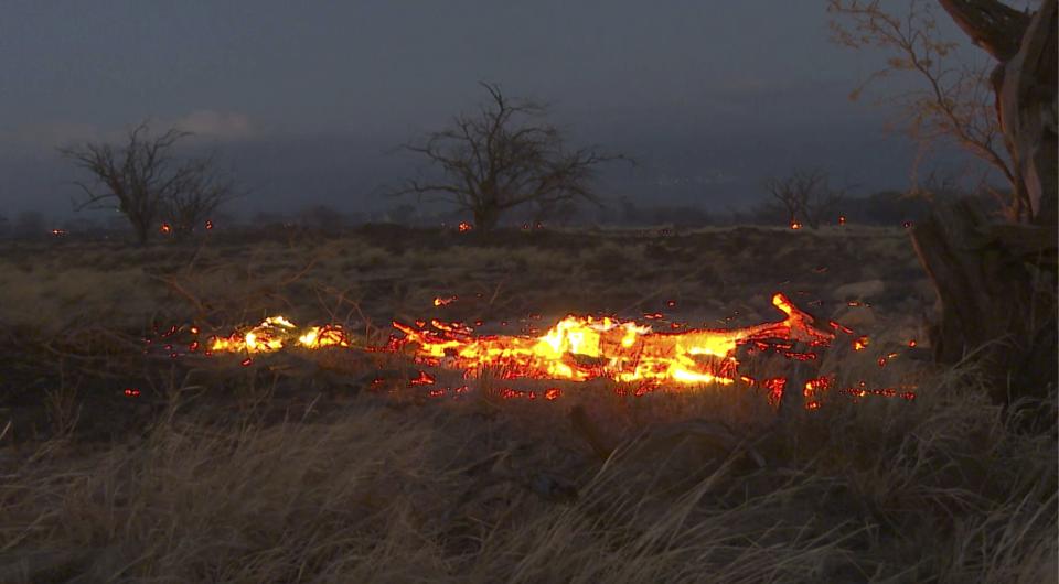 Flames from a wildfire burn in Kihei, Hawaii Wednesday, Aug. 9, 2023. Thousands of residents raced to escape homes on Maui as blazes swept across the island, destroying parts of a centuries-old town in one of the deadliest U.S. wildfires in recent years. (AP Photo/Ty O'Neil)