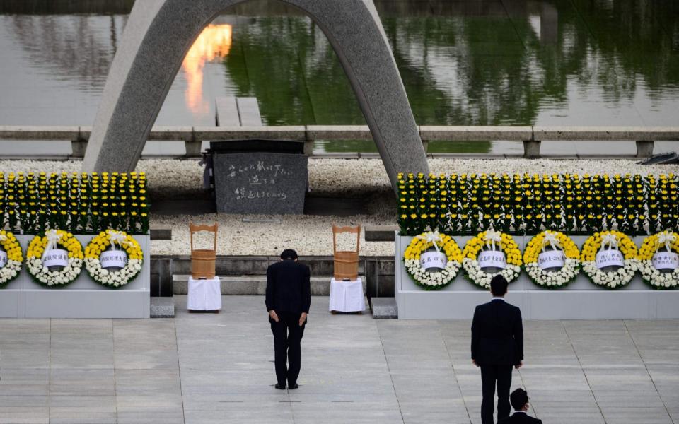 Japanese Prime Minister Shinzo Abe bows before the Memorial Cenotaph to commemorate the 75th anniversary of the Hiroshima bombing - PHILIP FONG  /AFP