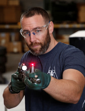 Rodger Brown checks the alignment of a front sight post assembly with a laser sight, at Spike's Tactical LLC, a gunmaker in Apopka, Florida, U.S. December 10, 2018. Picture taken December 10, 2018. REUTERS/Gregg Newton