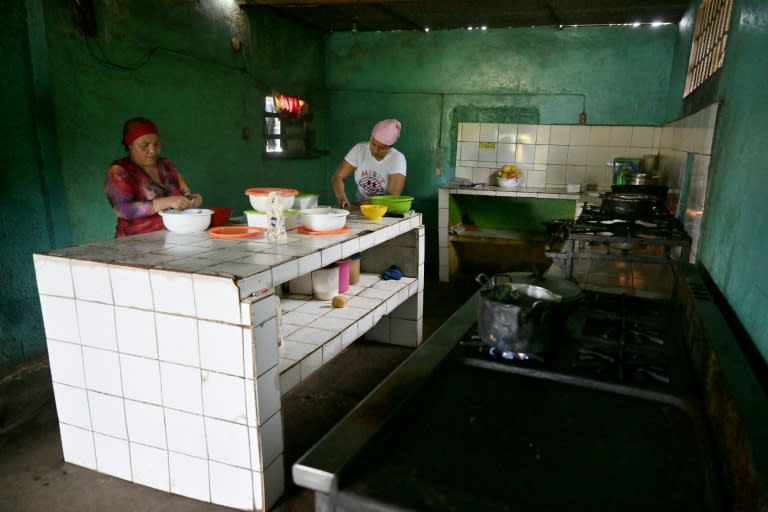 Corina Hernández y su tía Nazareth Mirabal (Izq.) preparan empanadas en su restaurante en Corozopando, estado de Guárico, Venezuela, el 30 de mayo de 2024, clausurado por 15 días luego de venderle comida a la opositora María Corina Machado (Juan BARRETO)