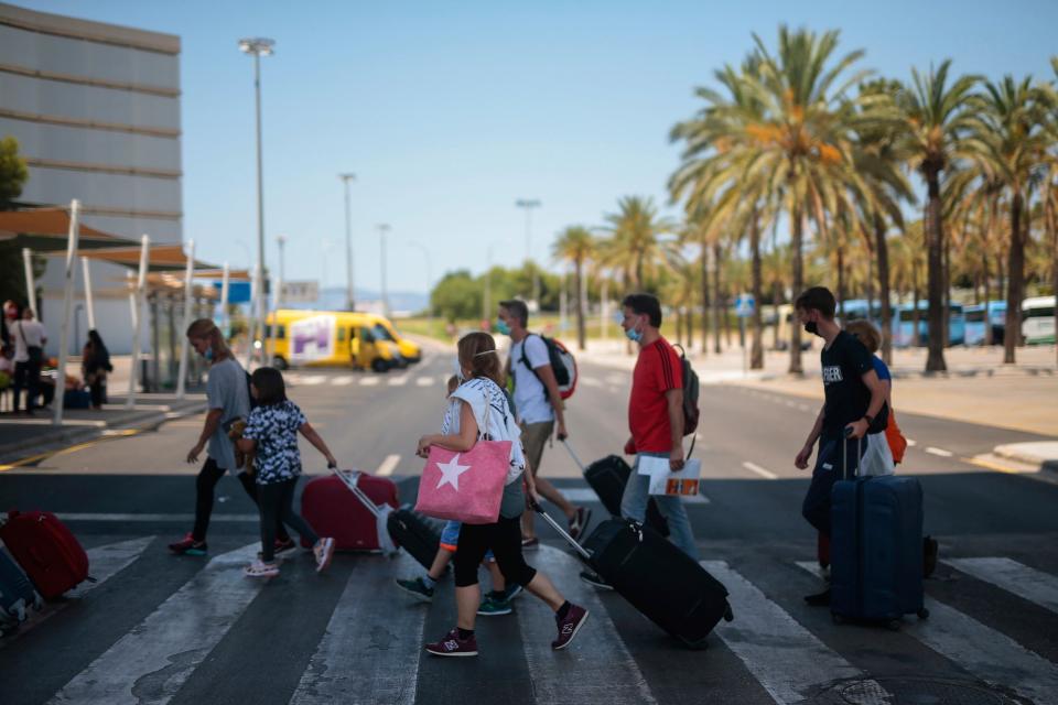 Passengers arrive at Son Sant Joan airport on the Spanish Balearic island of Palma de Mallorca, Spain on Sunday (AP)