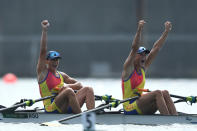 <p>Team Romania's Ancuta Bodnar and Simona Radis raise their hands in victory after winning the gold for Women's Double Sculls at Sea Forest Waterway on July 28.</p>