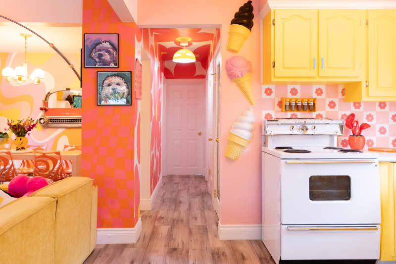 Yellow painted cabinets in colorful kitchen with flower motif backsplash.