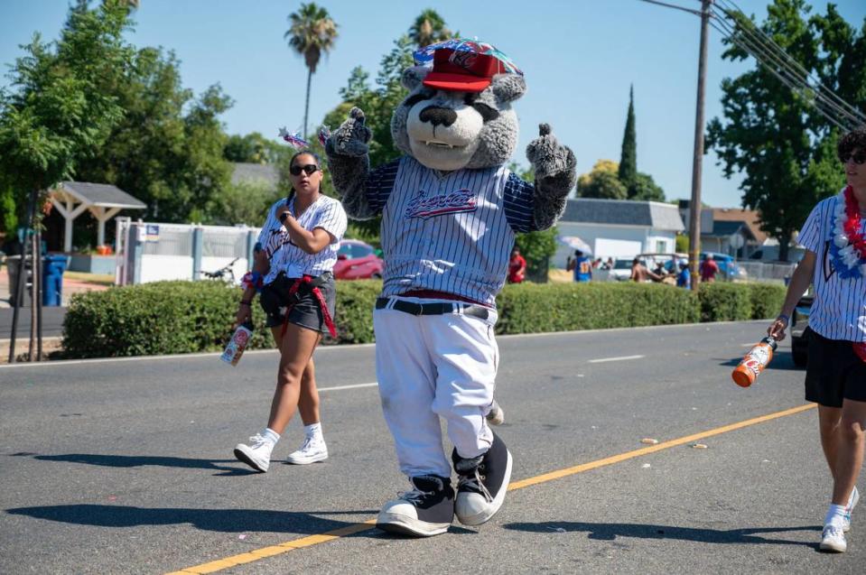 Sacramento River Cats mascot Dinger waves to Crowd at the Fourth of July Celebration parade down Coloma Road on Thursday.