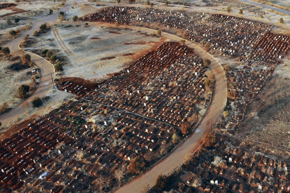 FILE - In this Aug. 5, 2020, file photo, recently filled graves are seen in the Olifantsveil Cemetery outside Johannesburg, South Africa. The African continent has surpassed 2 million confirmed cases as health officials warn of infections starting to creep up again into a second surge. (AP Photo/Jerome Delay/File)