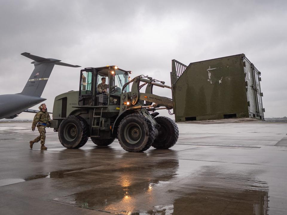 U.S. Air Force Staff Sgt. Jordan Chandanais, 731st Air Mobility Squadron special handling supervisor, and Senior Airman Joseph Holliday, 51st Logistics Readiness Squadron Documented Cargo ground transportation operator, transfer cargo to load onto a commercial KDC‐10 tanker aircraft at Osan Air Base, 2023. <em>U.S. Air Force</em> 