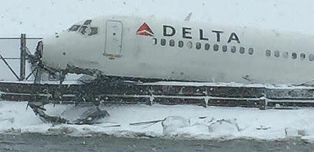 A Delta jet which skidded off the runway at Laguardia airport is seen jutting above a dyke in New York City March 5, 2015, in a photo provided by the New York Police Department. REUTERS/New York Police Department/handout via Reuters