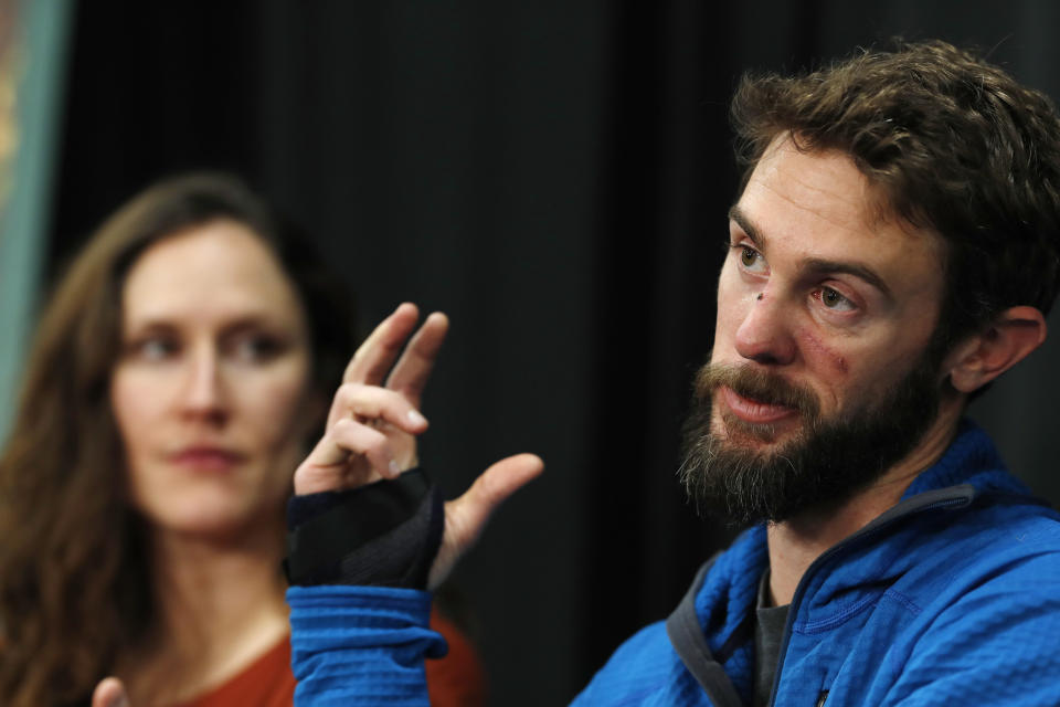 Travis Kauffman responds to questions during a news conference Thursday, Feb. 14, 2019, in Fort Collins, Colo., about his encounter with a mountain lion while running a trail just west of Fort Collins last week. Kaufman's girlfriend, Annie Bierbower, looks on. (AP Photo/David Zalubowski)