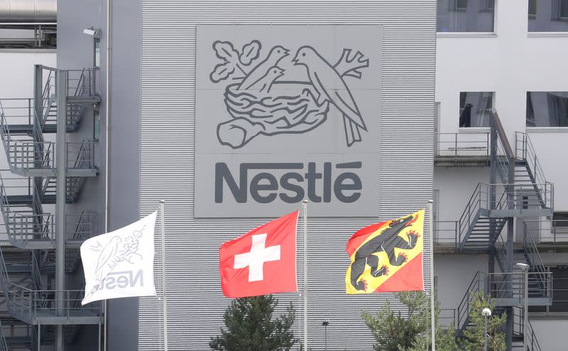 Foto de archivo. Una bandera nacional suiza ondea junto a una bandera del cantón de Berna frente al logotipo de Nestlé en una planta en Konolfingen