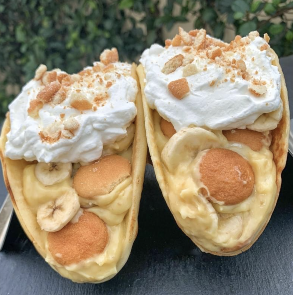 Two vanilla wafer tacos are doused in whipped cream and banana pudding